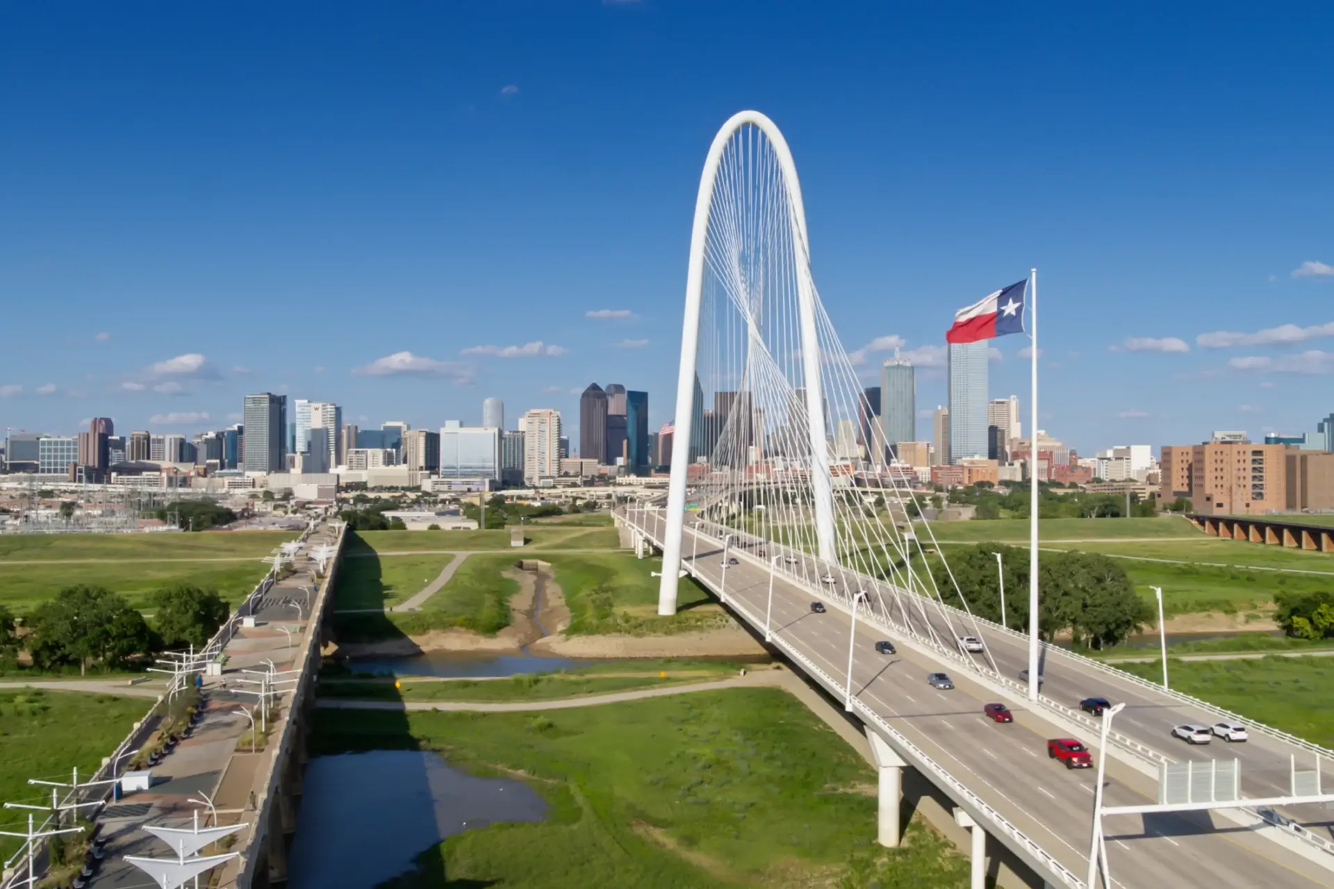 Bridge and skyline with Texas flag flying.