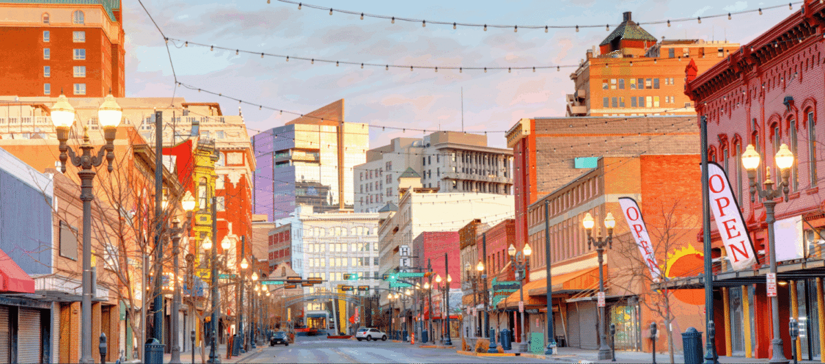 City street with buildings and lights at dusk.